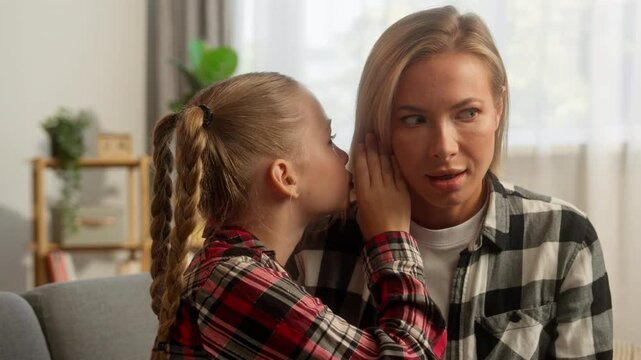 Shocked Caucasian female mother woman listening family kid daughter whisper gossip at home smiling child little schoolgirl sharing secret with lady mom parent girl talking rumour funny story custody