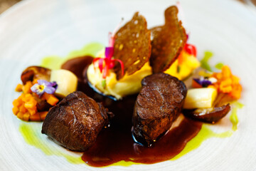 Deer tenderloin. Truffle-potato puree, porcini mushrooms, baked leek and carrot, juniper bread, port wine sauce. Delicious healthy traditional food served for lunch in modern gourmet restaurant