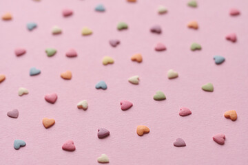Colorful small hearts on the pink background. Valentine's day concept seamless pattern