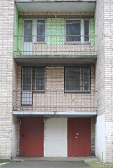 Entrance doors and balconies on the second and third floors of the brick house