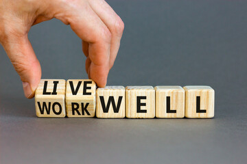 Live or work well symbol. Concept words Live well Work well on wooden cubes. Beautiful grey table grey background. Businessman hand. Business and live or work well concept. Copy space.