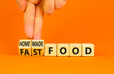 Fast or homemade food symbol. Concept words Fastfood or Homemade food on wooden cubes. Beautiful orange table orange background. Doctor hand Healthy lifestyle Fast or homemade food concept. Copy space
