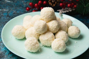 Christmas, delicious homemade candies with coconut flakes and almonds on a blue plate. Concept of delicious holiday homemade food