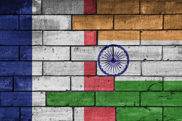colourful painted big flag of france and flag of india on a massive old brick wall background. concept