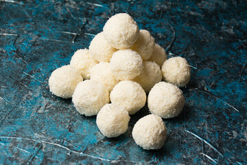 Delicious homemade candies with coconut flakes and almonds on a dark background. Concept of delicious holiday homemade dishes