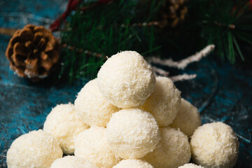 Christmas, delicious homemade candies with coconut flakes and almonds on a dark background. Concept of delicious holiday homemade dishes