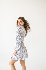 Naklejka premium beautiful woman model posing in white polka dot dress in studio