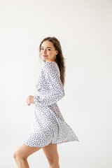 Naklejka premium beautiful woman model posing in white polka dot dress in studio