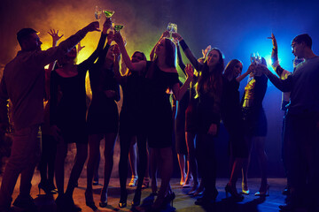 Group of young people, boys and girls, students have fun in nightclub, attending party, dancing...