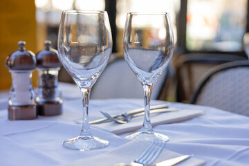 Elegant table setting for fine dining with wine glasses and cutlery in bright restaurant atmosphere
