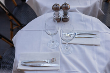 Elegant table setting for fine dining with wine glasses and cutlery in bright restaurant atmosphere