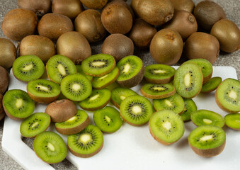 Fresh kiwi fruit, whole and sliced kiwi on the table.