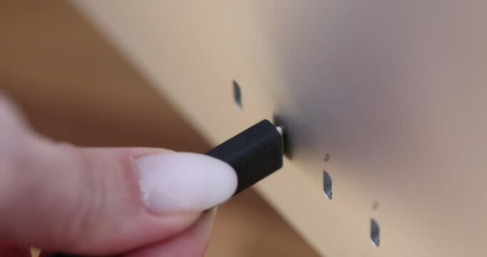 Connecting a USB-C cable to a stylish device during a tech demo