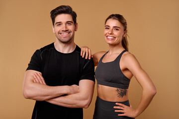 An Energetic Fitness Duo is Posing Confidently Against a Warm and Inviting Backdrop