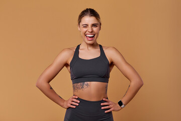 A Fit Woman Smiling Happily in Trendy Sportswear Set Against a Warm and Inviting Background