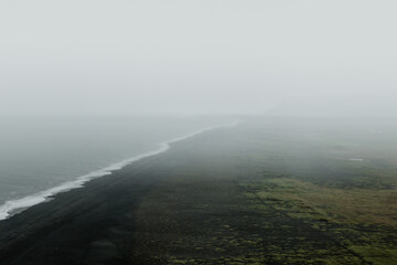 Misty morning view of the black sand beach at Dyrhólaey, South Iceland, with foggy coastal landscapes