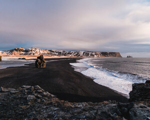 Arnardrangur sea stack and Reynisdrangar basalt columns on the black sand beach, South Iceland.