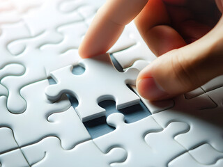 close-up hand holding white jigsaw or puzzle piece of game