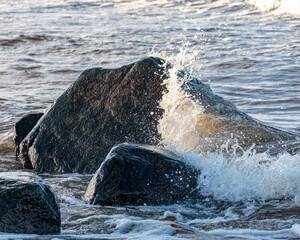 landscape with the seashore, windy winter day, water splashes, icy stones on the seashore, Baltic...