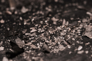 Scattered burnt ashes and debris on a dark background