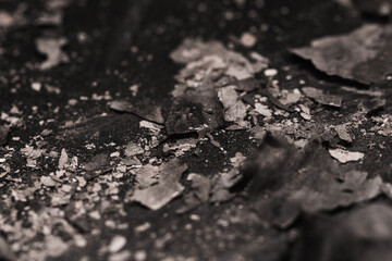 Scattered burnt ashes and debris on a dark background