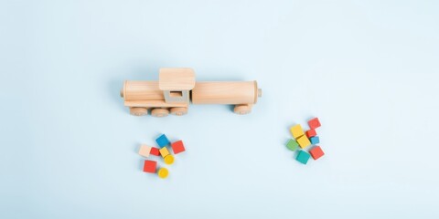 Wooden train and colorful blocks on a light blue background, perfect for childhood development and educational games.