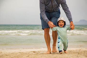 Junge spielt mit Papa am Strand auf Mallorca