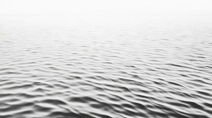 Fototapeta premium Serene black and white ocean waves gently lapping against the shore under a foggy sky