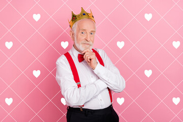 Portrait of attractive minded gray-haired man wearing tiara deciding isolated over pink pastel...