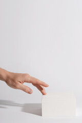 Female hand and luxury white block pedestal for product showcase