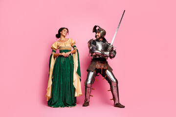 Elegant couple in fantasy medieval costumes on pink studio background