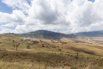 Scenic view of traditional Masai village surrounded by mountains in Serengeti Tanzania East Africa