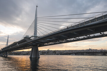 Sunset view of Halic Metro Bridge and cityscape of Istanbul with cloudy sky. Istanbul Turkiye