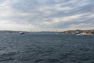 Obraz premium Panorama view from the deck of the ferry to Bosphorus, Istanbul, Turkey. Seascape near the Uskudar pier. Cloudy day and seagulls.