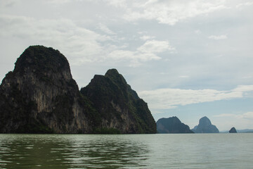 Naklejka premium Limestone cliffs rise dramatically above the emerald-green waters