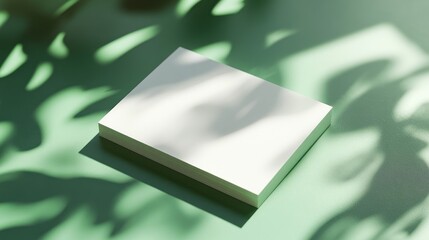 Blank paper stack, sunlight, green background, mock-up