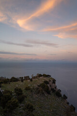 Dramatic sunset views from Monte Pellegrino's Belvedere in Palermo, capturing the rugged Mediterranean coastline against a canvas of golden-orange clouds.
