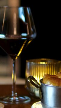 Shabbat or Sabbath kiddush ceremony composition with a traditional sweet fresh loaf of challah bread, glass of red kosher wine and candles on a vintage wood table with copy space