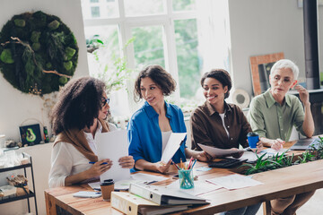 Photo of successful corporate women speak hold documents modern interior office business center indoors