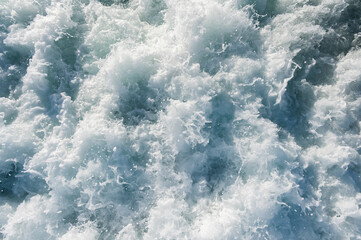 Vibrant ocean waves creating foam patterns. Bubbling and foaming sea water