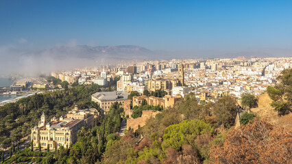 Fototapeta premium Malaga, seaside city in Andalusia, Spain, Europe. Panoramic view of a city nestled amongst hills and mountains under a clear blue sky.