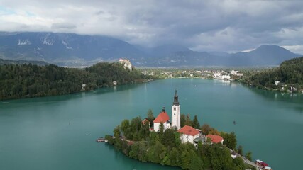 lake bled island church reflection with castle on mountain cliff background (famous european travel tourism destination in julian alps) slovenia europe scenic landscape sunset glow boat rowing nature