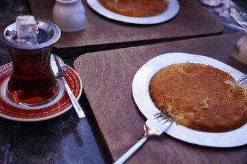 traditional Turkish dessert kunefe and Turkish tea on the table. Breakfast in a Turkish-style coffee shop