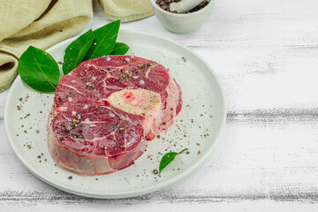 Raw ossobuco beef meat with spices and fresh herbs. Veal shank steak, traditional Italian ingredient