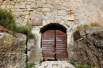 Fototapeta premium wooden door and brick wall of ancient crimea sight. tourist place. part of fort.