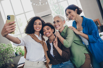 Photo of lovely four businessladies feminist meeting community take selfie photo comfortable startup meeting office room interior