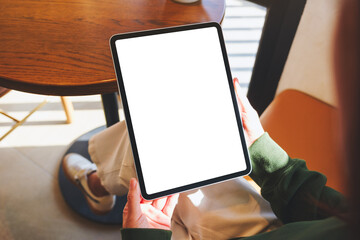 Mockup image of a woman holding digital tablet with blank desktop screen in cafe