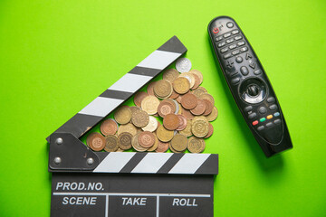 TV remote controller and movie clapper board on the green background.