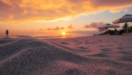 Serene sunset on a beach with sand dunes and distant figures under umbrellas