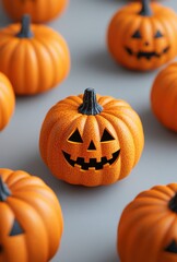 Charming collection of vibrant orange artificial pumpkins featuring whimsical faces arranged on a softly textured surface, symbolizing the festive spirit of Halloween celebrations and seasonal decor.